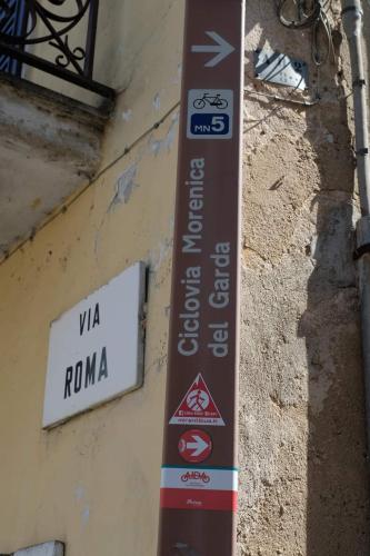 a street sign on the side of a building at La casa dei ciclisti in Ponti Sul Mincio