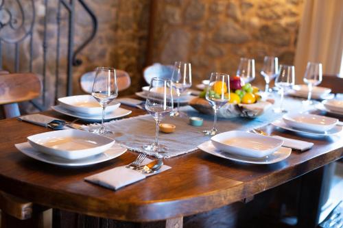 a wooden table with plates and wine glasses on it at Stone Mill House in Vrh