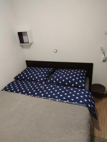a bed with a blue pillow with white stars at Apartments Zagreb Center in Zagreb