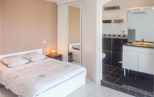 マルセイヤンにあるStunning Home In Marseillan With 3 Bedrooms, Wifi And Outdoor Swimming Poolのベッドルーム1室(ベッド1台付)、バスルーム(シンク付)