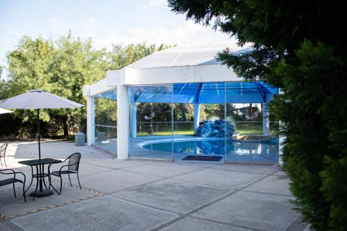 a pavilion with a pool and a table and chairs at Hotel Victoria Express in Durango