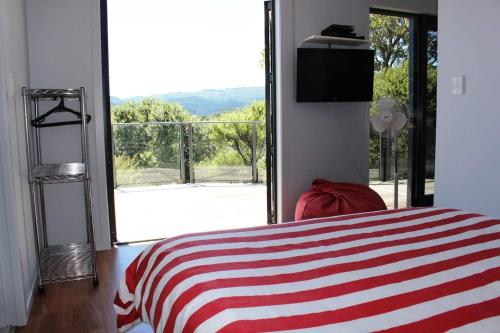 ein Schlafzimmer mit einem Bett und einem großen Fenster in der Unterkunft Poppy Apartment in Coromandel Town