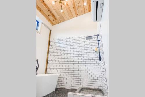 a bathroom with a white tiled shower with a toilet at A Suite with a View + Wine in Mount Airy