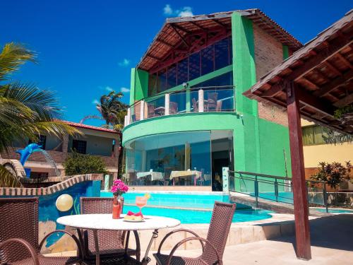 a villa with a pool and a table and chairs at Planet Dunas Residence in Aquiraz