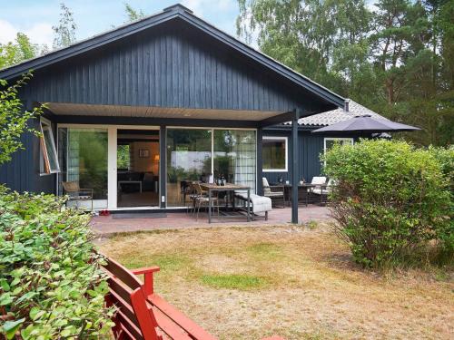 a blue house with a patio and a table at 7 person holiday home in Aakirkeby in Vester Sømarken