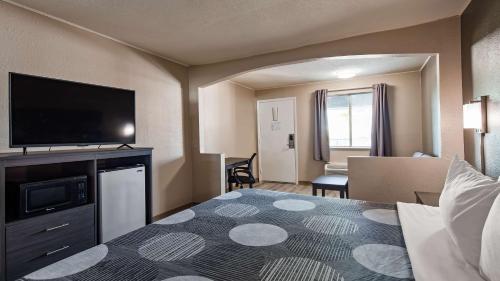 a hotel room with a bed and a flat screen tv at SureStay Hotel By Best Western Olathe in Olathe