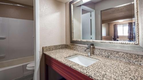 a bathroom with a sink and a mirror at SureStay Hotel By Best Western Olathe in Olathe