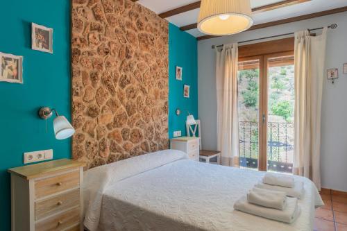 a bedroom with a bed and a brick wall at Miralmundo Alojamientos rurales Ayna - CASA RURAL 3 estrellas in Ayna