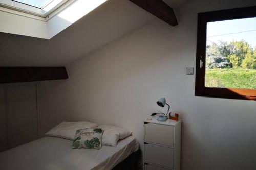 una camera con un piccolo letto e una finestra di Maison océane proche plage ad Arès