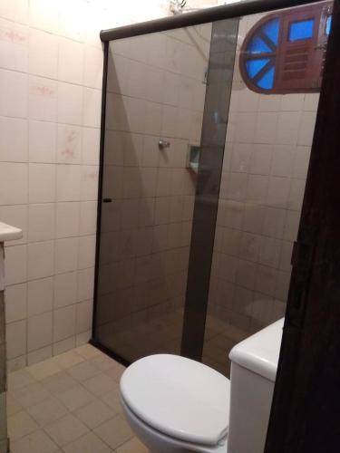 a bathroom with a toilet and a glass shower at Casa no centro de Bananeiras PB in Bananeiras
