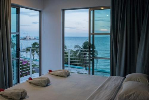 - une chambre avec un grand lit et une vue sur l'océan dans l'établissement Hotel Noor, à Chetumal