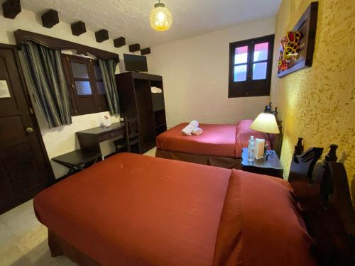 a hotel room with two beds and a sink at Hotel Posada San Pedro in Antigua Guatemala