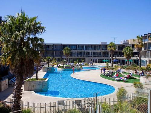 a resort swimming pool with a hotel in the background at Resort Hotel Room 273 in Torquay