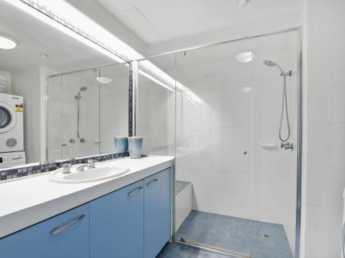 a white bathroom with a sink and a shower at The Rocks Resort Unit 5D in Gold Coast