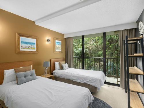 two beds in a room with a window at The Rocks Resort Unit 3D in Gold Coast