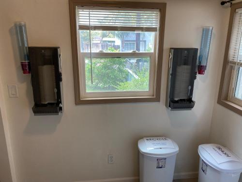 a bathroom with two trash cans and a window at WHOLE Family - Barrette (front) in Sacramento