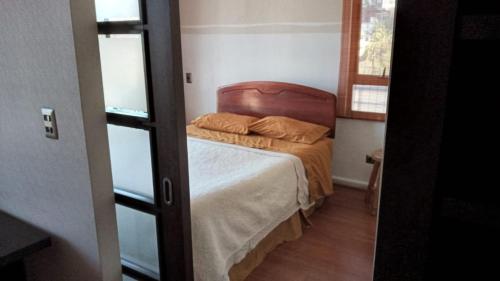 a small bedroom with a bed and a window at Viña Park 2 in Viña del Mar
