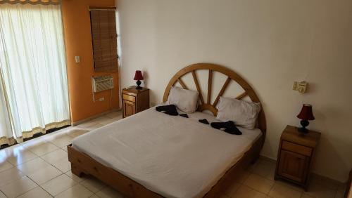 a bedroom with a large bed with a wooden headboard at Europa Hotel and Condo in Sosúa