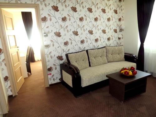 a living room with a couch and a flower patterned wall at West Plaza Residence in Bucharest