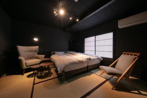 a bedroom with a bed and a table and chairs at Yasuraginoyado Yufu in Beppu