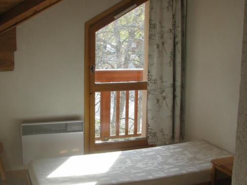 uma janela num quarto com uma cama em frente em Appartement Valloire, 4 pièces, 8 personnes - FR-1-263-484 em Valloire
