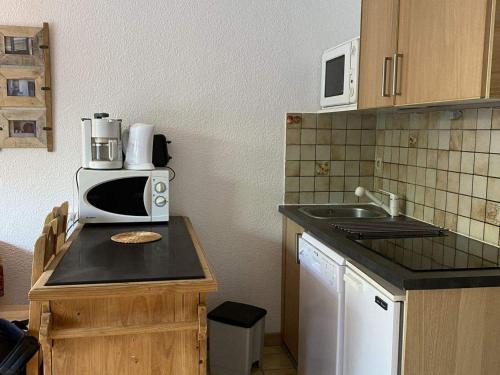 a kitchen with a microwave on top of a counter at Studio Valloire, 1 pièce, 4 personnes - FR-1-263-486 in Valloire