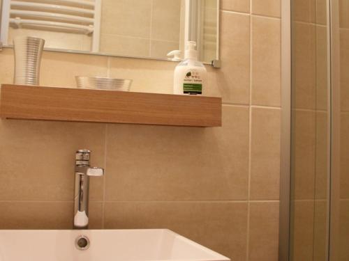 W łazience znajduje się umywalka, lustro i półka. w obiekcie Appartement Valloire, 1 pièce, 4 personnes - FR-1-263-481 w mieście Valloire