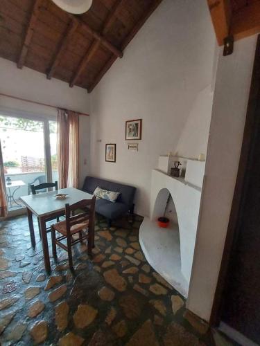 a living room with a table and a fireplace at Beautiful house located on a hill in Samos Island, 400 m from an organized beach in Koumeika