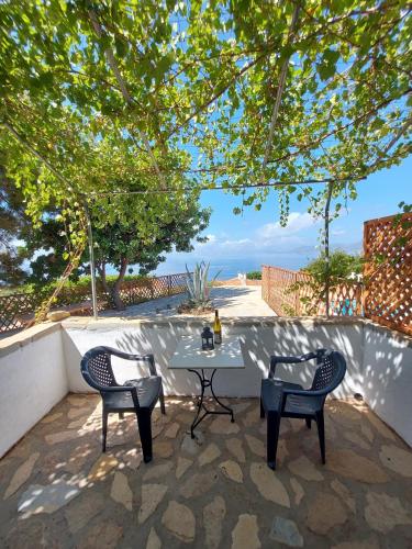 a table and chairs on a patio with a view of the ocean at Beautiful house located on a hill in Samos Island, 400 m from an organized beach in Koumeika