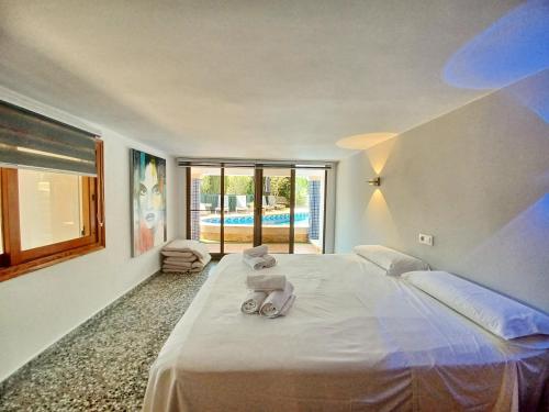 ein Schlafzimmer mit einem großen weißen Bett mit Handtüchern darauf in der Unterkunft Villa Sun Carlos in Benissa