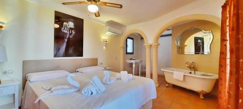ein Schlafzimmer mit einem Bett, einer Badewanne und einem Waschbecken in der Unterkunft Villa Sun Carlos in Benissa