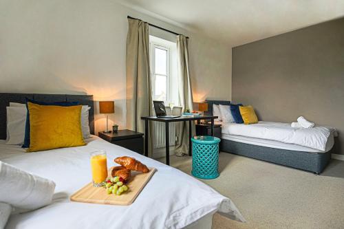 a hotel room with two beds and a tray of food at Premium 4 large double bed townhouse in Bicester, next to Bicester Village in Bicester