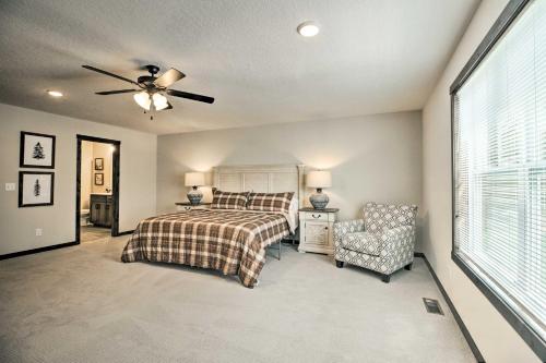 a bedroom with a bed and a ceiling fan and a chair at Upscale Townhome in Causeways on Gull Resort! in Nisswa