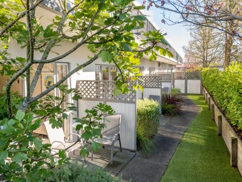a house with a fence and a garden at Lake Taupo Motor Inn in Taupo