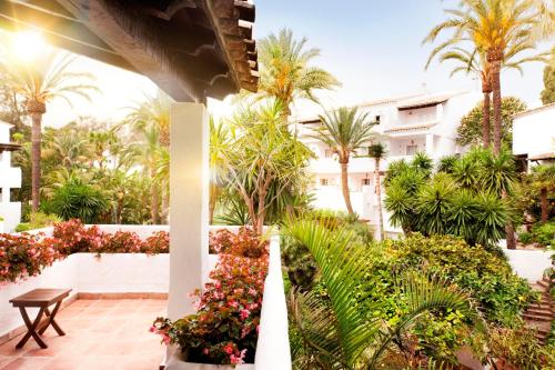 a view of a courtyard with palm trees and flowers at Puente Romano Marbella in Marbella