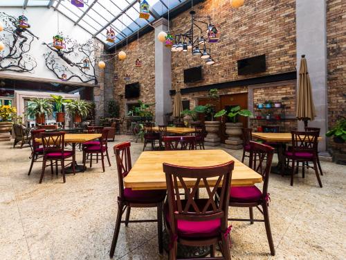 a dining room with wooden tables and chairs at Quinta del Rey Hotel in Toluca