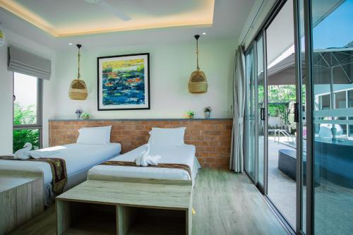 Кровать или кровати в номере Yipmunta Pool Villa - SHA Plus Certified