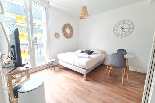 1 dormitorio con 1 cama, escritorio y TV en Le Poulorio 6 - Studio - Proche Gare By Locly, en Lorient