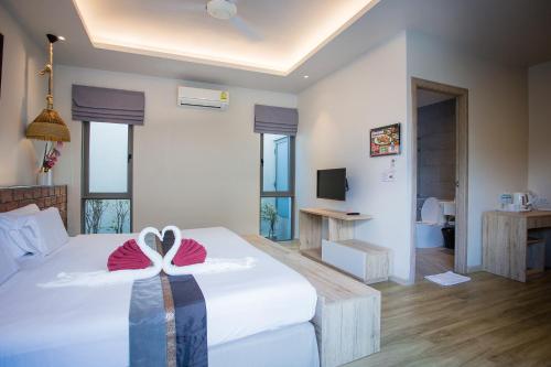 a bedroom with a bed with a bow on it at Yipmunta Pool Villa - SHA Plus Certified in Bang Tao Beach