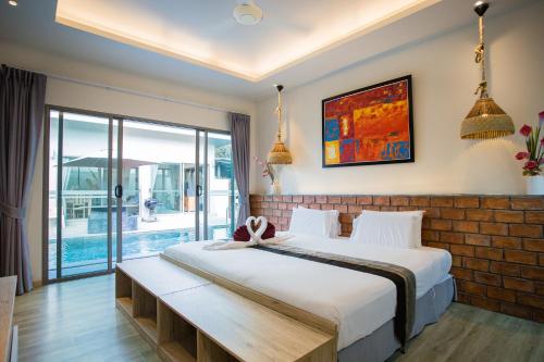 a bedroom with a large bed and a balcony at Yipmunta Pool Villa - SHA Plus Certified in Bang Tao Beach