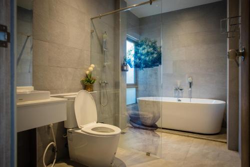 a bathroom with a tub and a toilet and a sink at Yipmunta Pool Villa - SHA Plus Certified in Bang Tao Beach