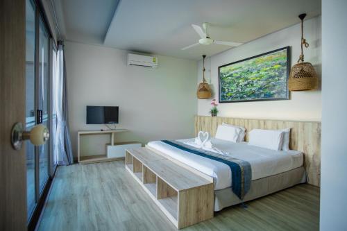 a bedroom with a large bed and a tv at Yipmunta Pool Villa - SHA Plus Certified in Bang Tao Beach