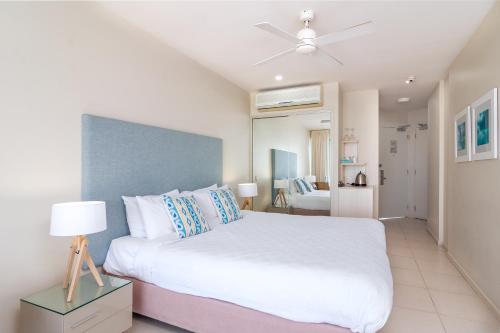 a bedroom with a white bed with a ceiling fan at 201 Lake Street in Cairns