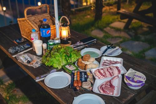 a picnic table with meat and vegetables on it at Hotel SANG SANG & Private SANG SANG POOL VILLA in Geoje 