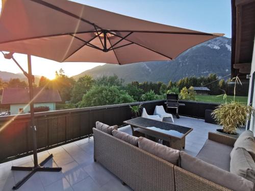 a patio with an umbrella and chairs and a table at Haus Seewald in Passriach