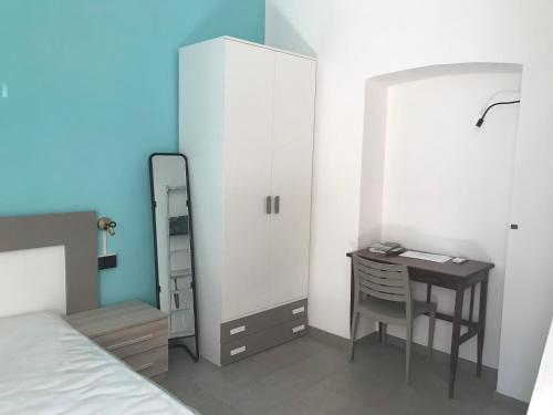 1 dormitorio con escritorio, 1 cama y espejo en Appartamento Gloria, en Cremona