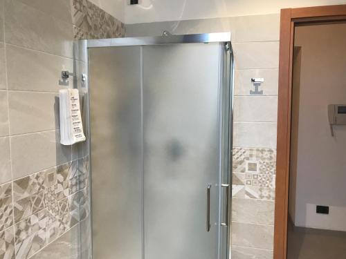una doccia con porta in vetro in bagno di Appartamento Gloria a Cremona