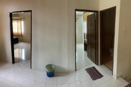 un corridoio con 2 specchi e pavimento piastrellato di Awani Homestay Seberang Jaya a Permatang Janggus