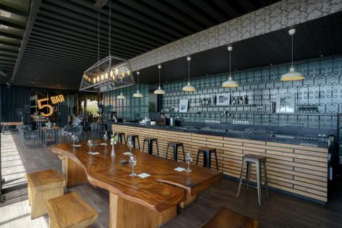 a restaurant with a wooden table and a bar at Java Heritage Hotel Purwokerto in Purwokerto
