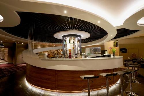 a restaurant with a bar with stools in a room at Java Heritage Hotel Purwokerto in Purwokerto